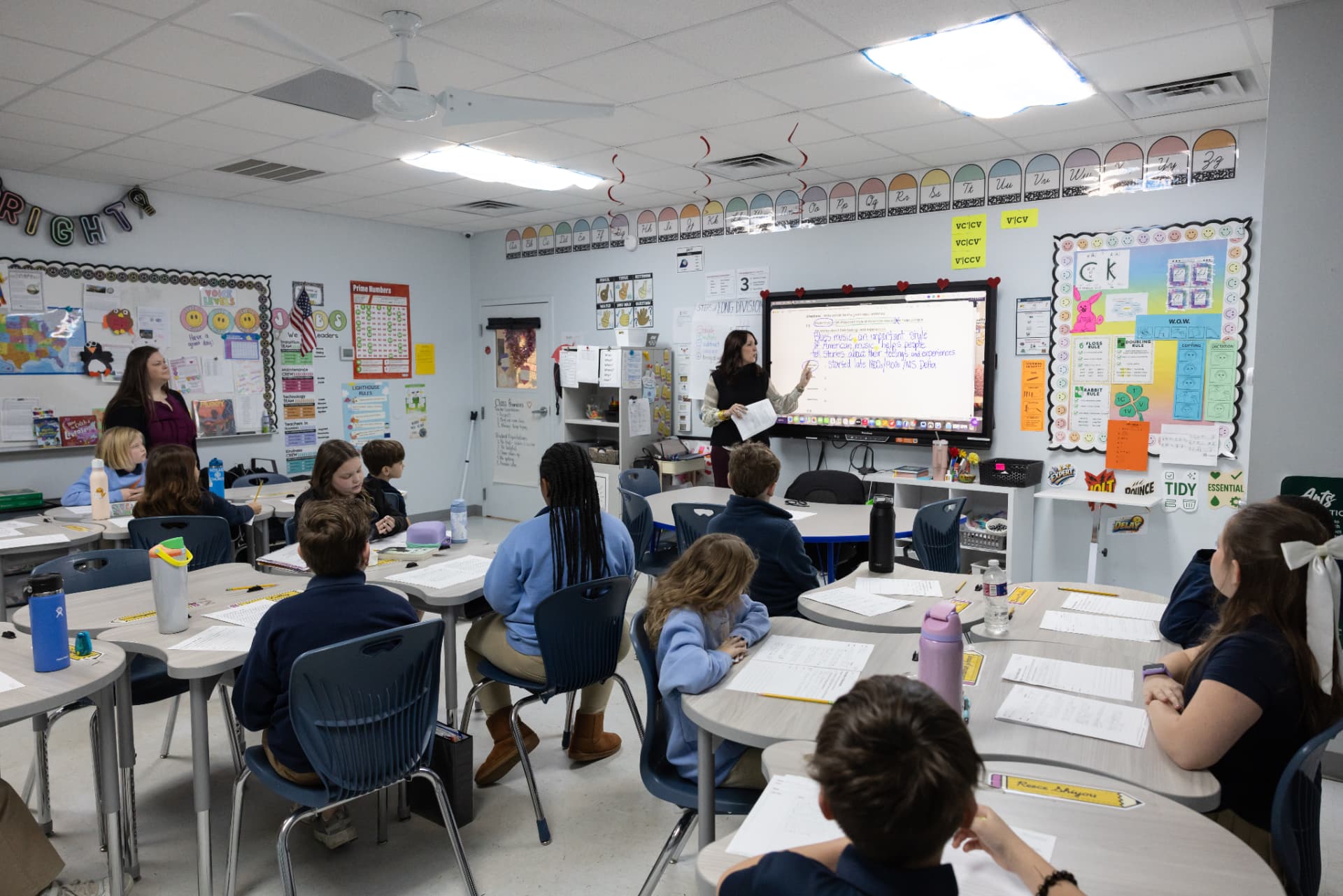 A full classroom of students following a lesson on the interactive board