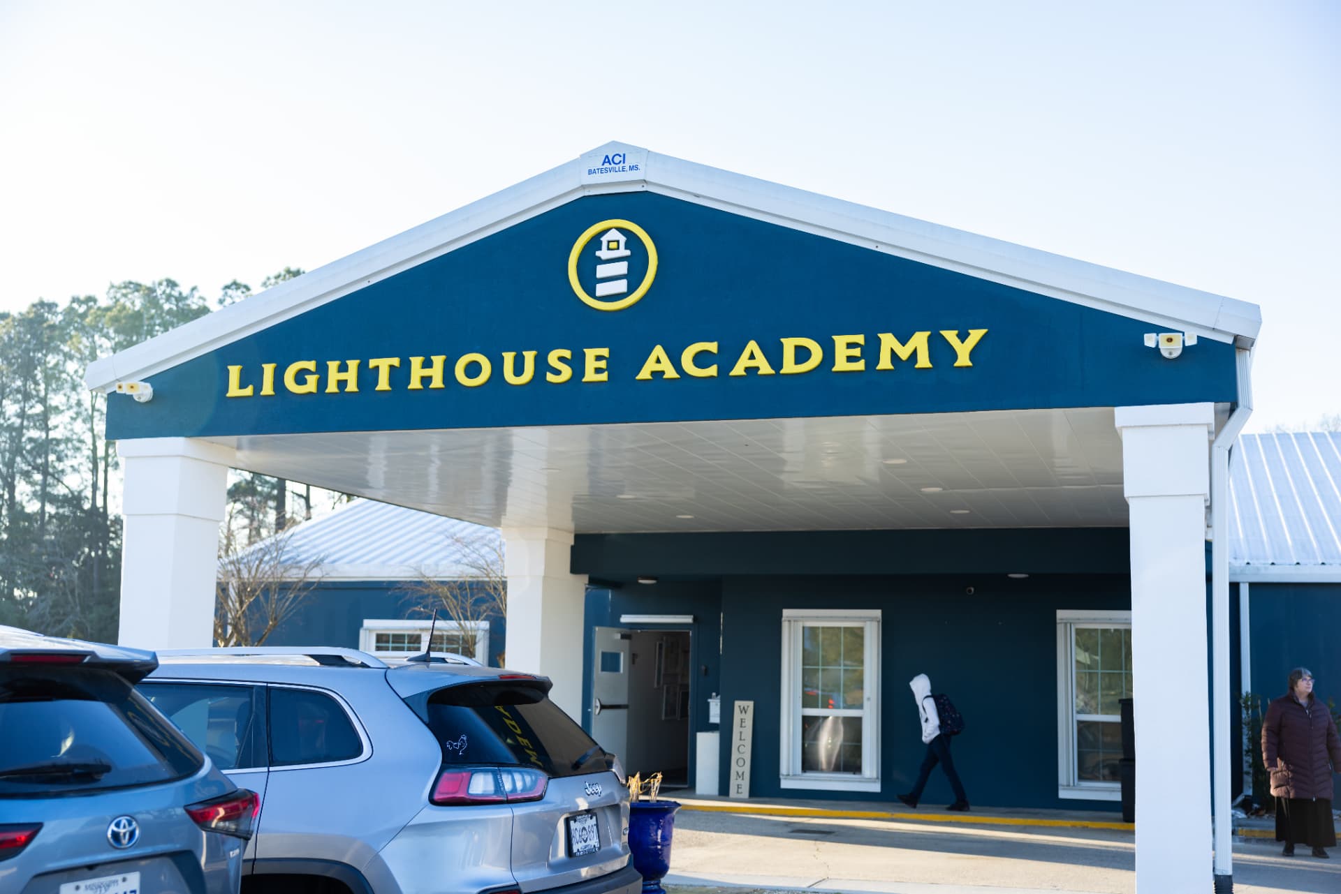 The navy and gold Lighthouse Academy entrance canopy on a clear morning